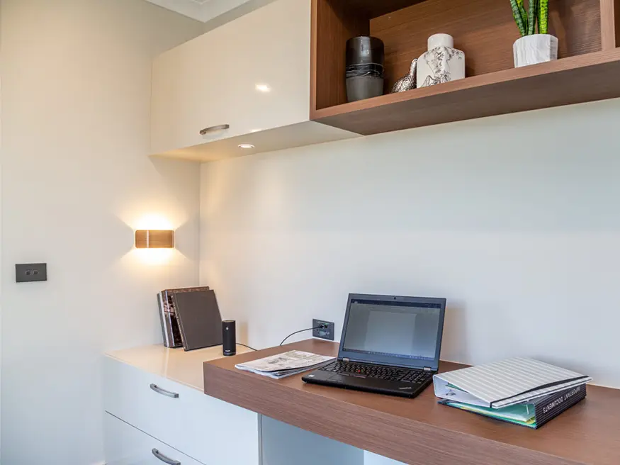 Laptop computer on a wooden desk in a home office.