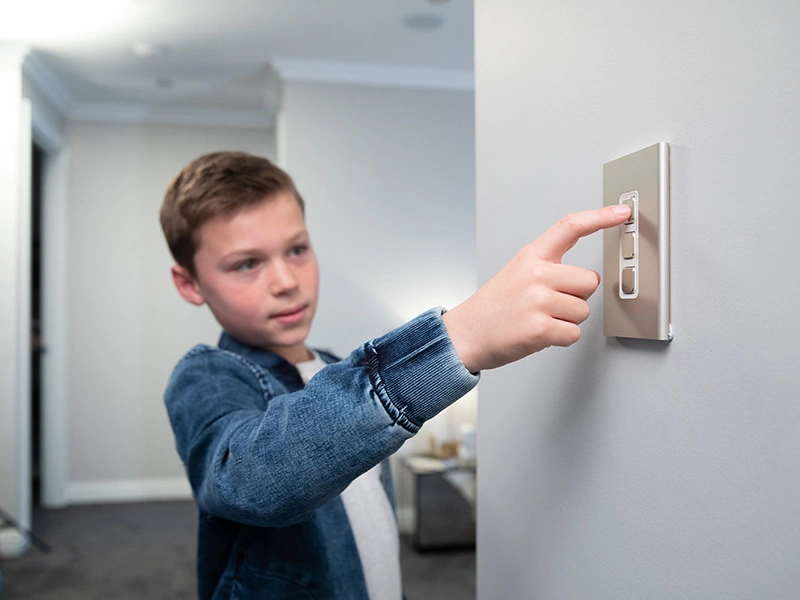 A boy pressing the light switch