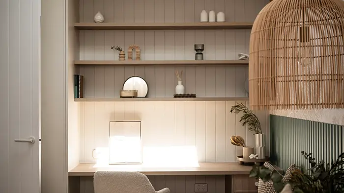 Desk with shelves attached to the wall, with a chair in front.