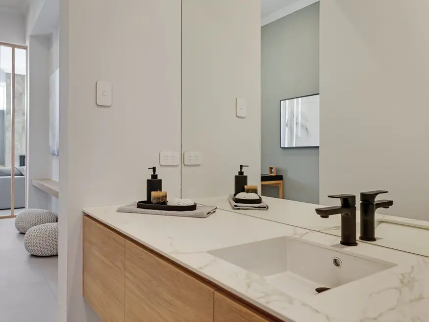 Bathroom with a black vessel sink and a gold faucet.