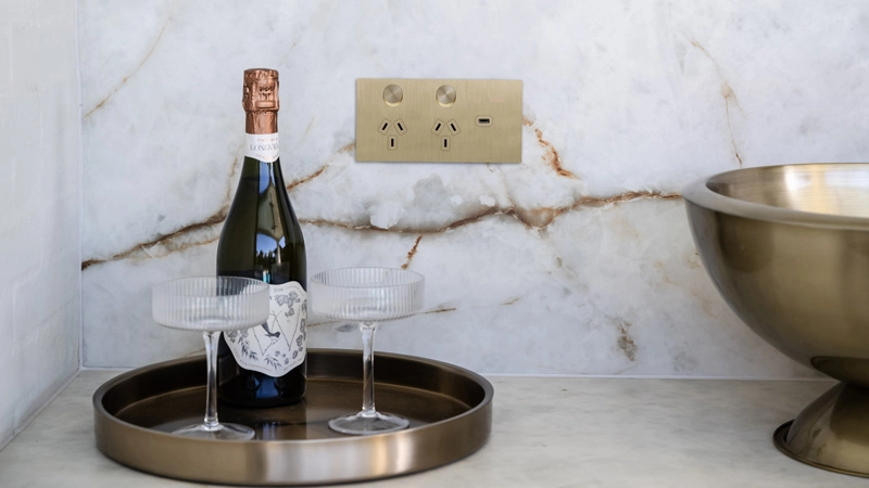 Solis brass power outlet and a bottle of champagne and two glasses on a tray