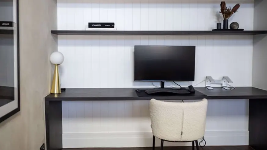 Computer desk with chair and monitor.