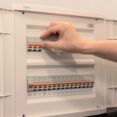 A hand examining the PDL switchboard closely for inspection