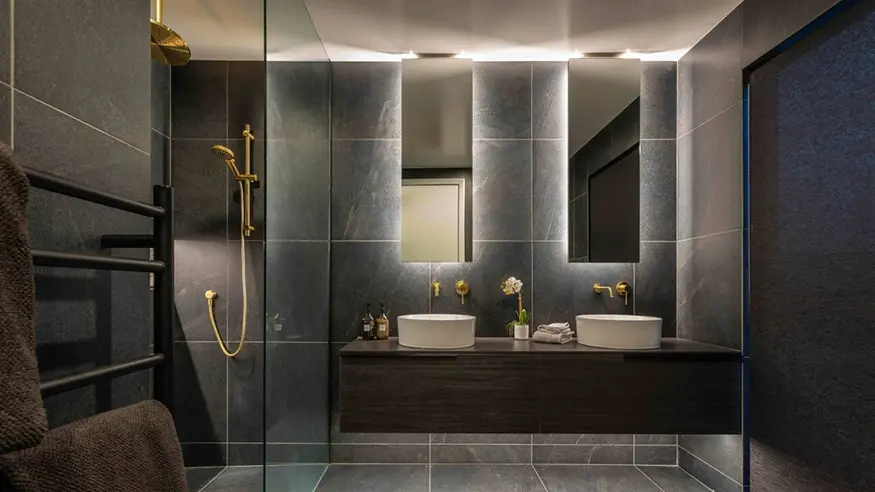 Modern bathroom with double sinks and a walk-in shower.