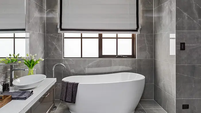 Bathroom with bathtub, sink, and window.