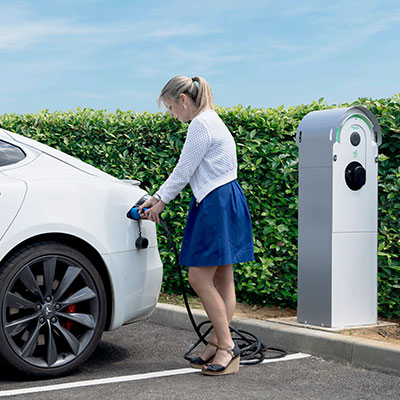 Woman charging her electric car with EV charger