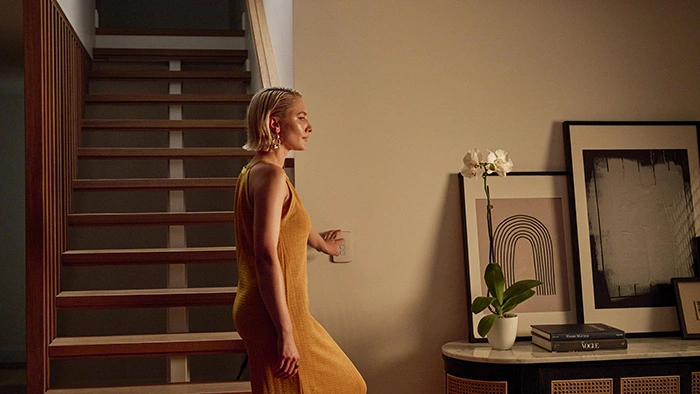 Woman in a yellow dress passing through a hallway