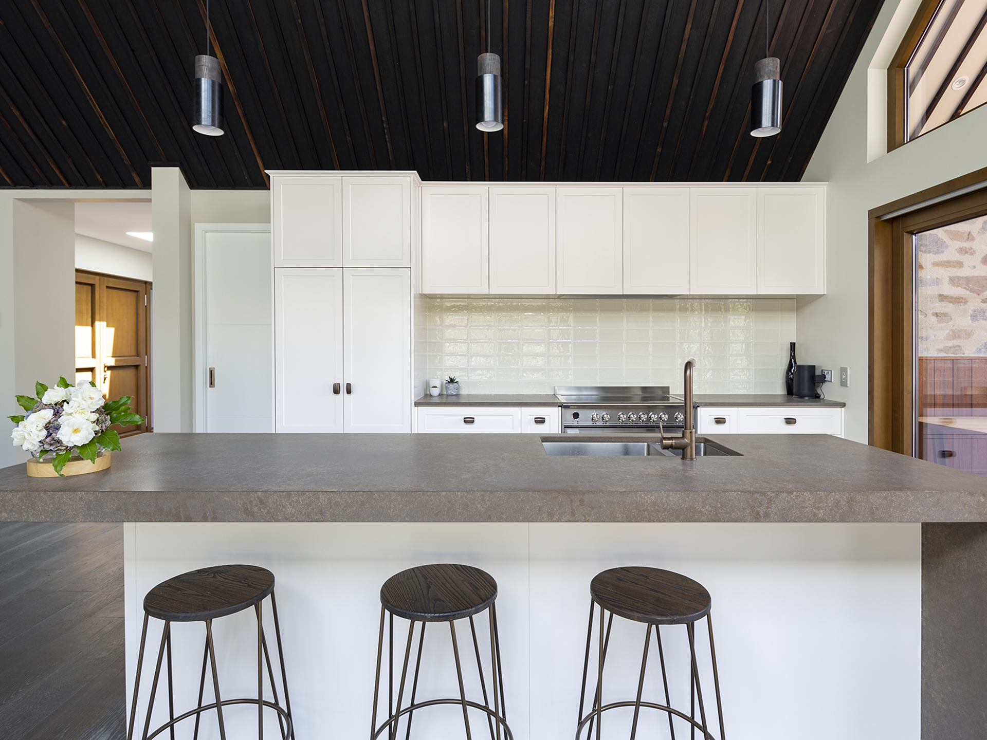 A cozy kitchen with a stylish counter and inviting stools.